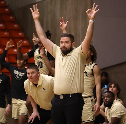 Plano East head coach Matt Wester, front, waits in anticipation with the team bench before a...