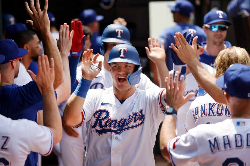 Texas Rangers third baseman Josh Jung (6) is congratulated by teammates in the dugout after...
