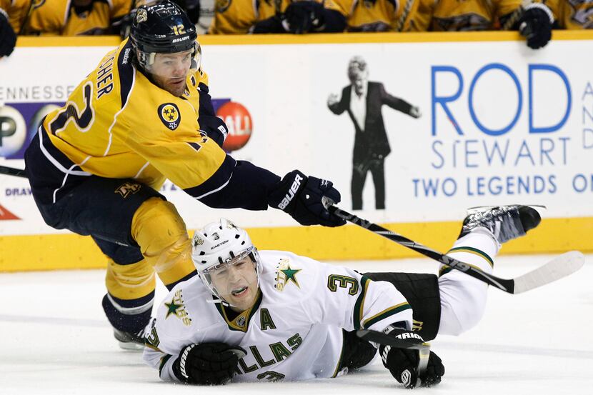 Dallas Stars' Steve Ott has the puck fly by his head as he tussles with Columbus' Rick Nash...