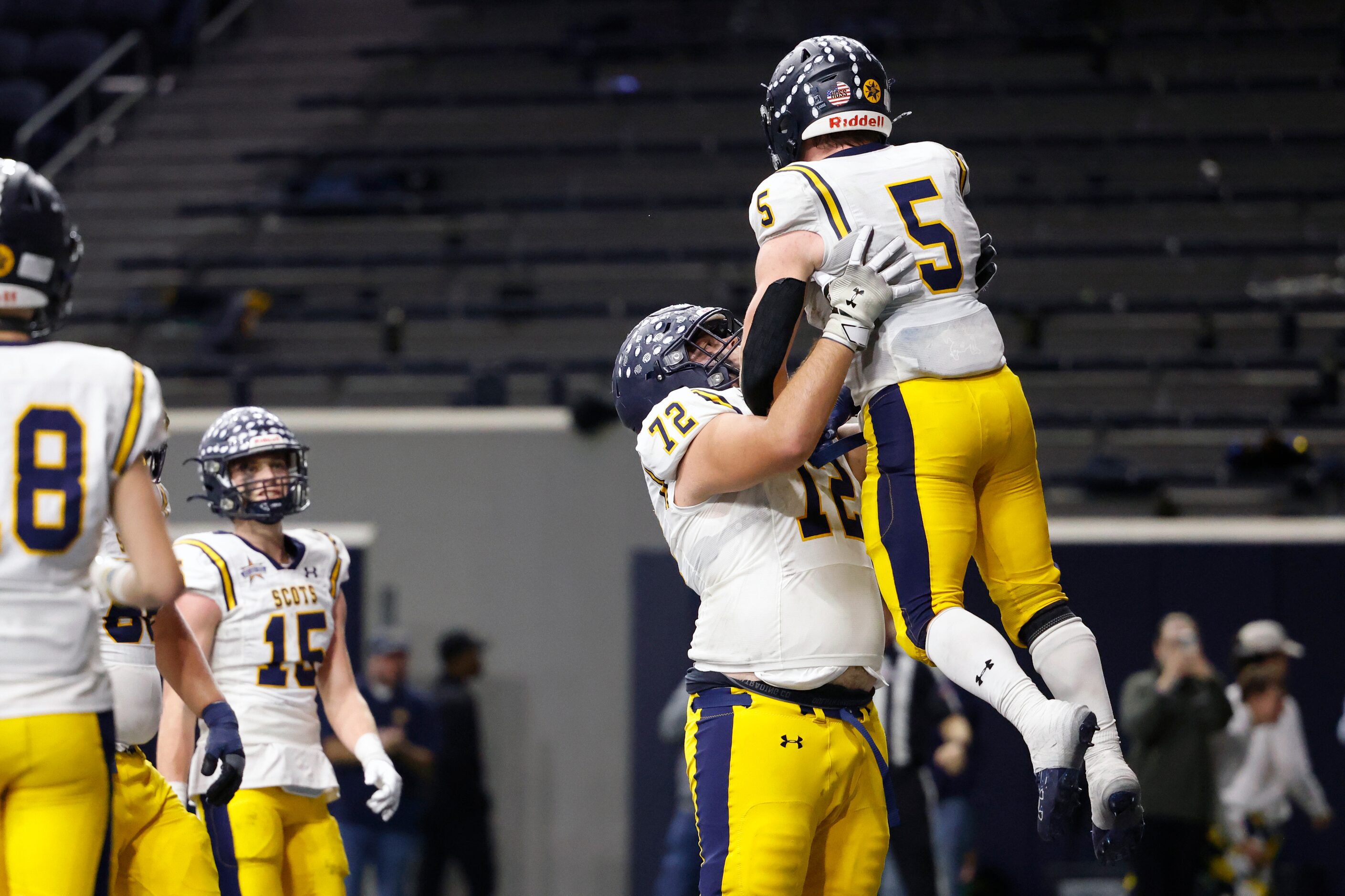 Highland Park offensive lineman Will Ogle (72) lifts running back James Lancaster (5) as...