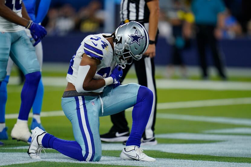 Dallas Cowboys running back Malik Davis kneels in the end zone after scoring a rushing...