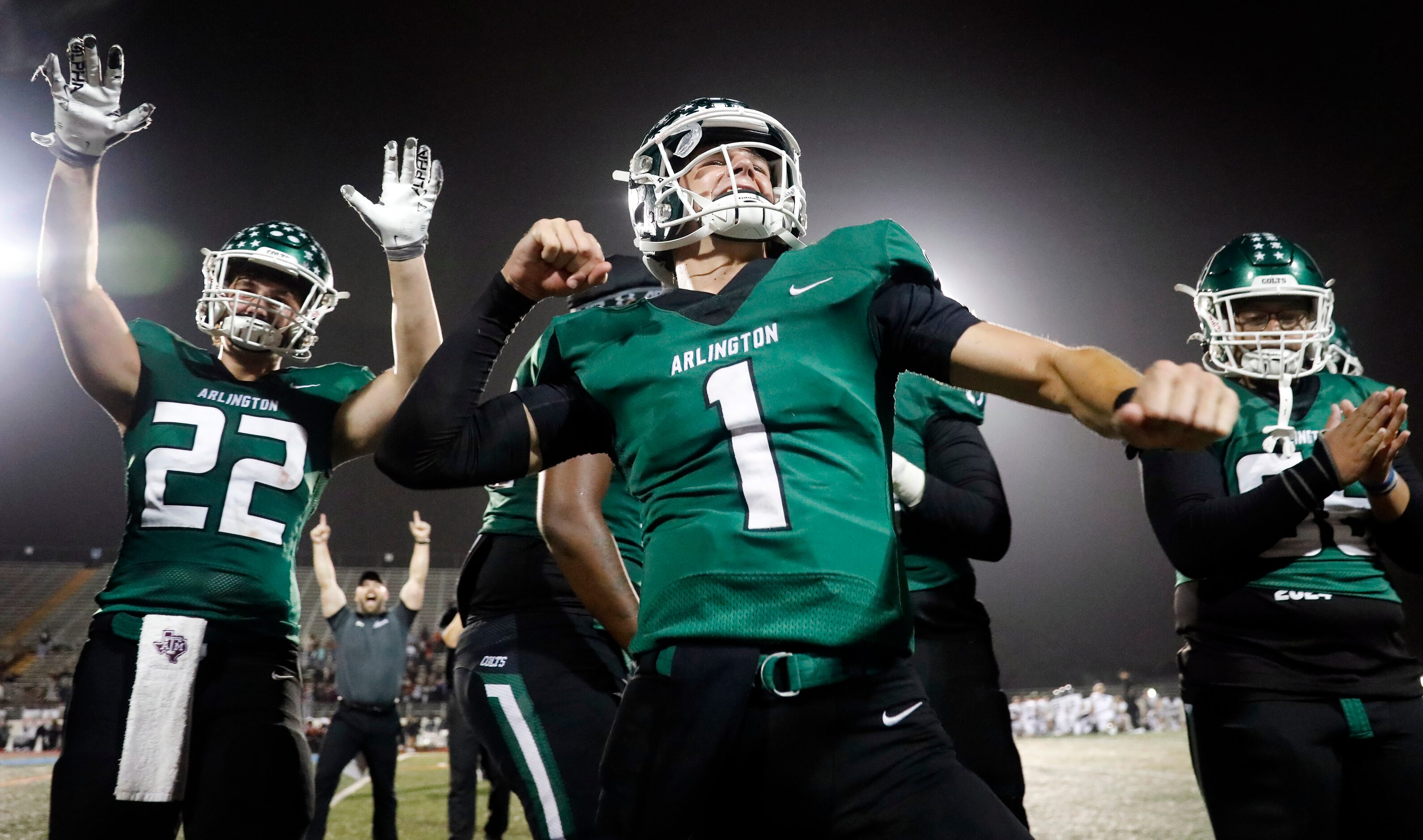 Arlington High quarterback Coleman Cravens (1) celebrate their 49-31 win over Arlington...