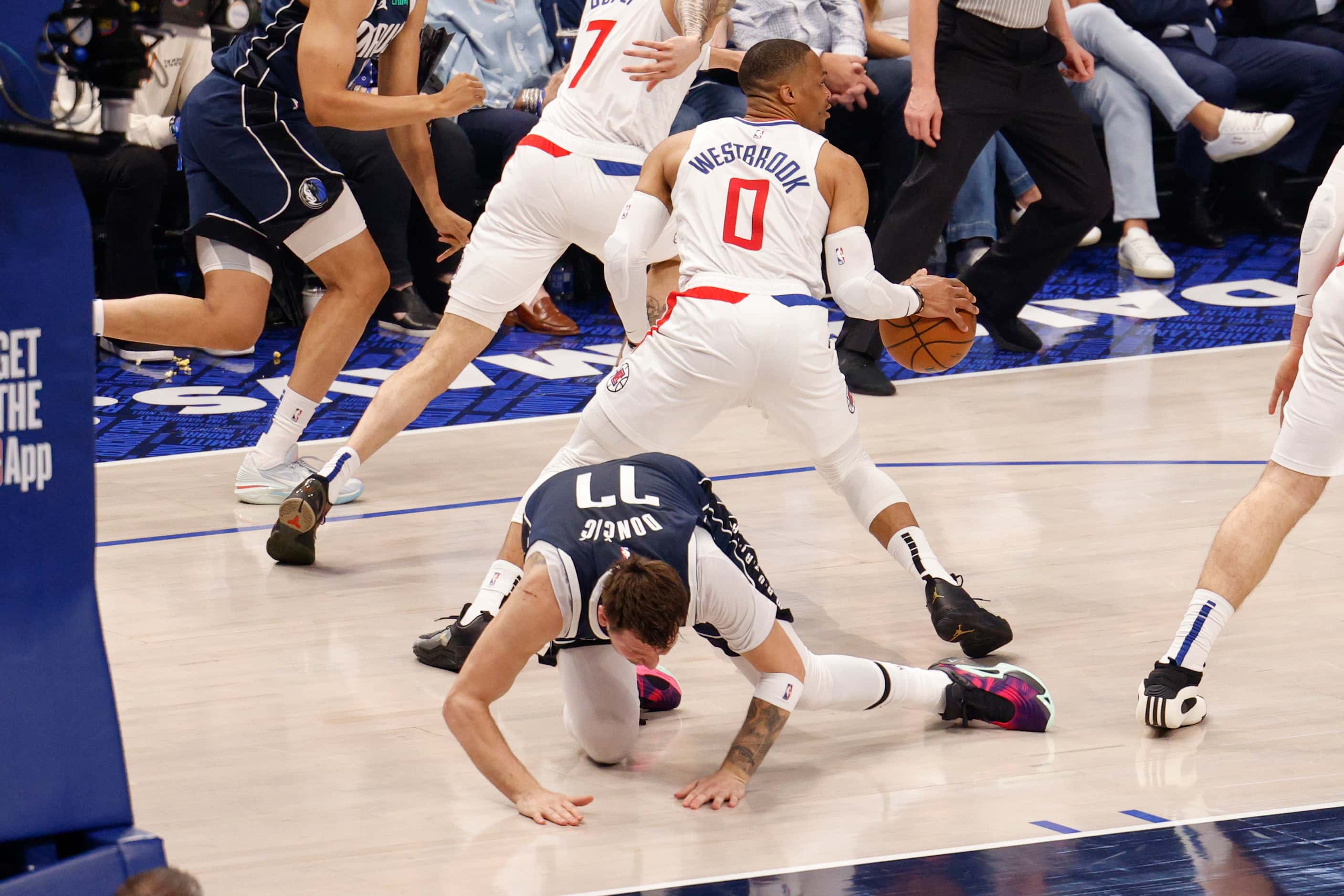 Dallas Mavericks guard Luka Doncic (77) falls to the ground after colliding with with LA...