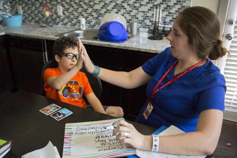  Jacob Casablanca (left) high-fives speech therapist Elizabeth Price during their session...