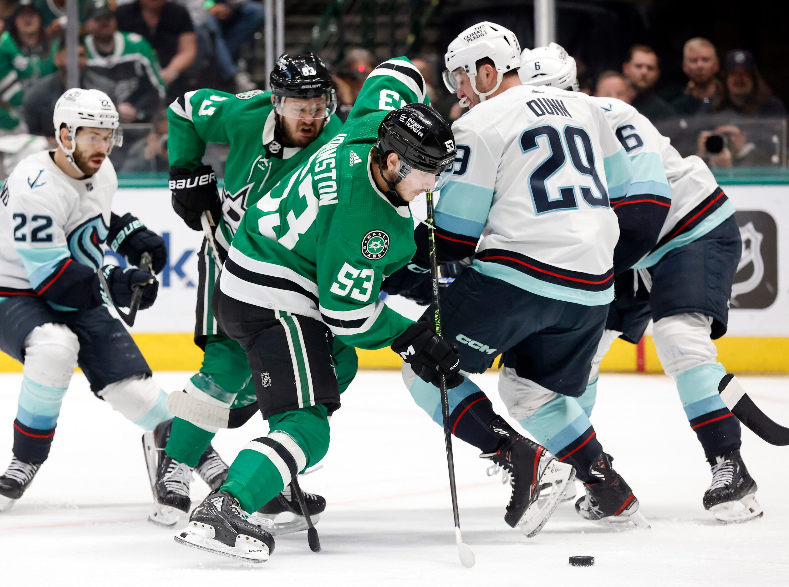 Dallas Stars center Wyatt Johnston (53) eyes the puck as he gets tangled up with Seattle...