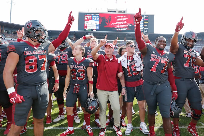 Oklahoma head coach Brent Venables, center, and players celebrate 52-42 victory over Kansas...
