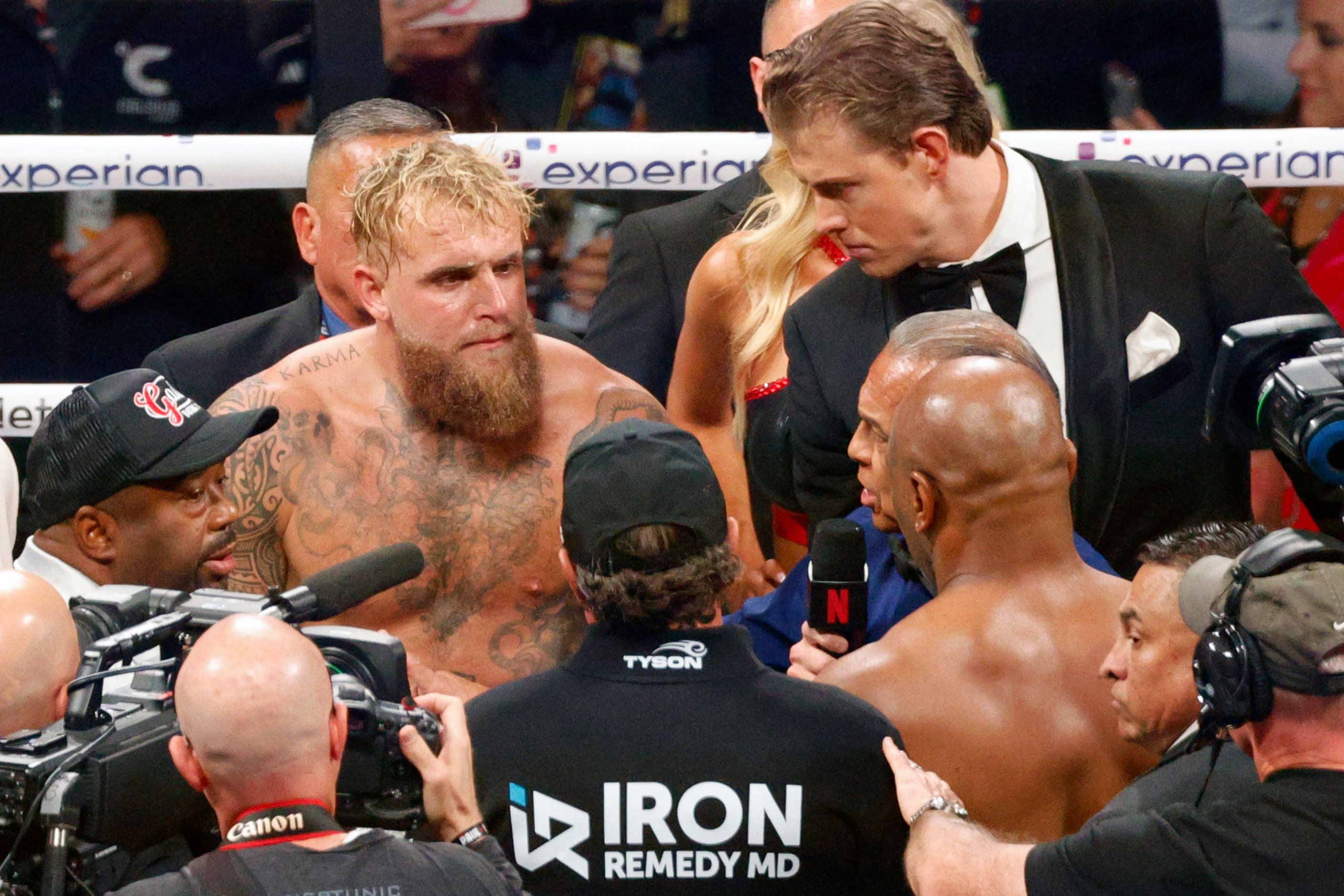 Jake Paul and Mike Tyson listen to the referee’s instructions before a heavyweight boxing...