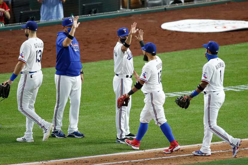 Rangers second baseman Rougned Odor (12) celebrates with manager Chris Woodward (8, center)...