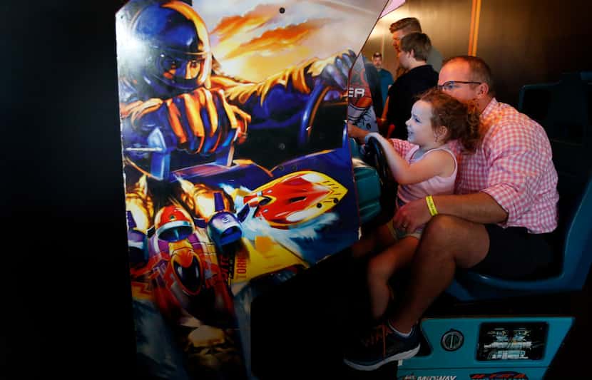 James Purl helps his daughter Collins Purl, 5, play a racing game at Free Play in Richardson.