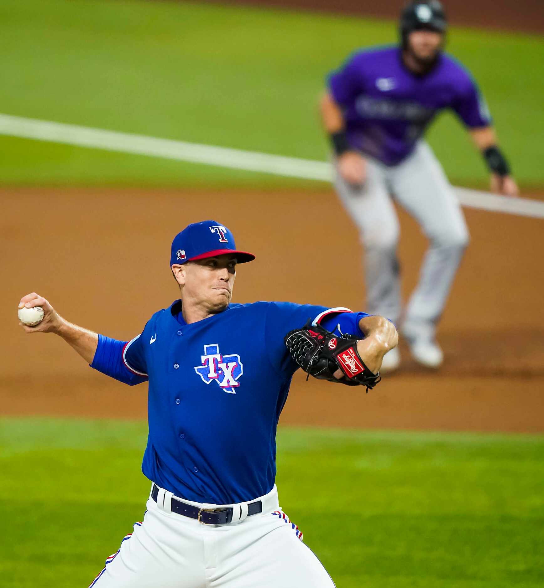 Texas Rangers pitcher Kyle Gibson pitches as Colorado Rockies outfielder David Dahl takes a...