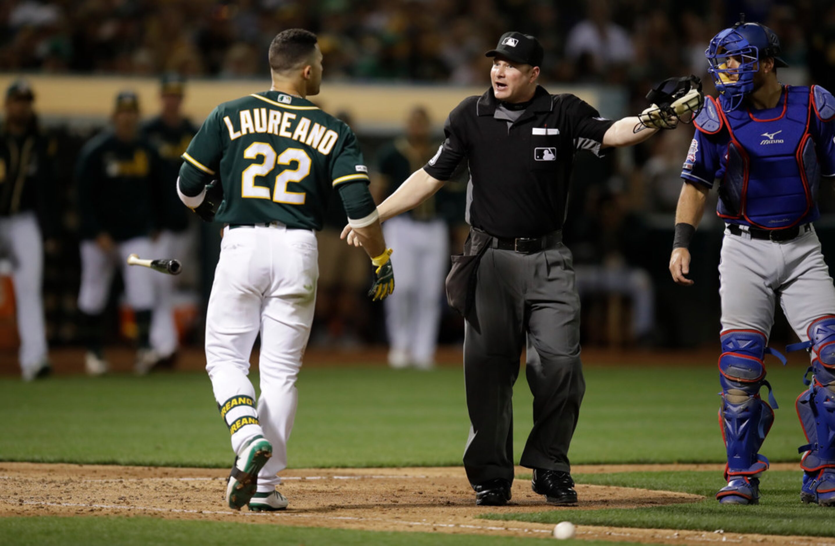 Oakland Athletics' Ramon Laureano (22) throws his bat after being hit by a pitch thrown by...