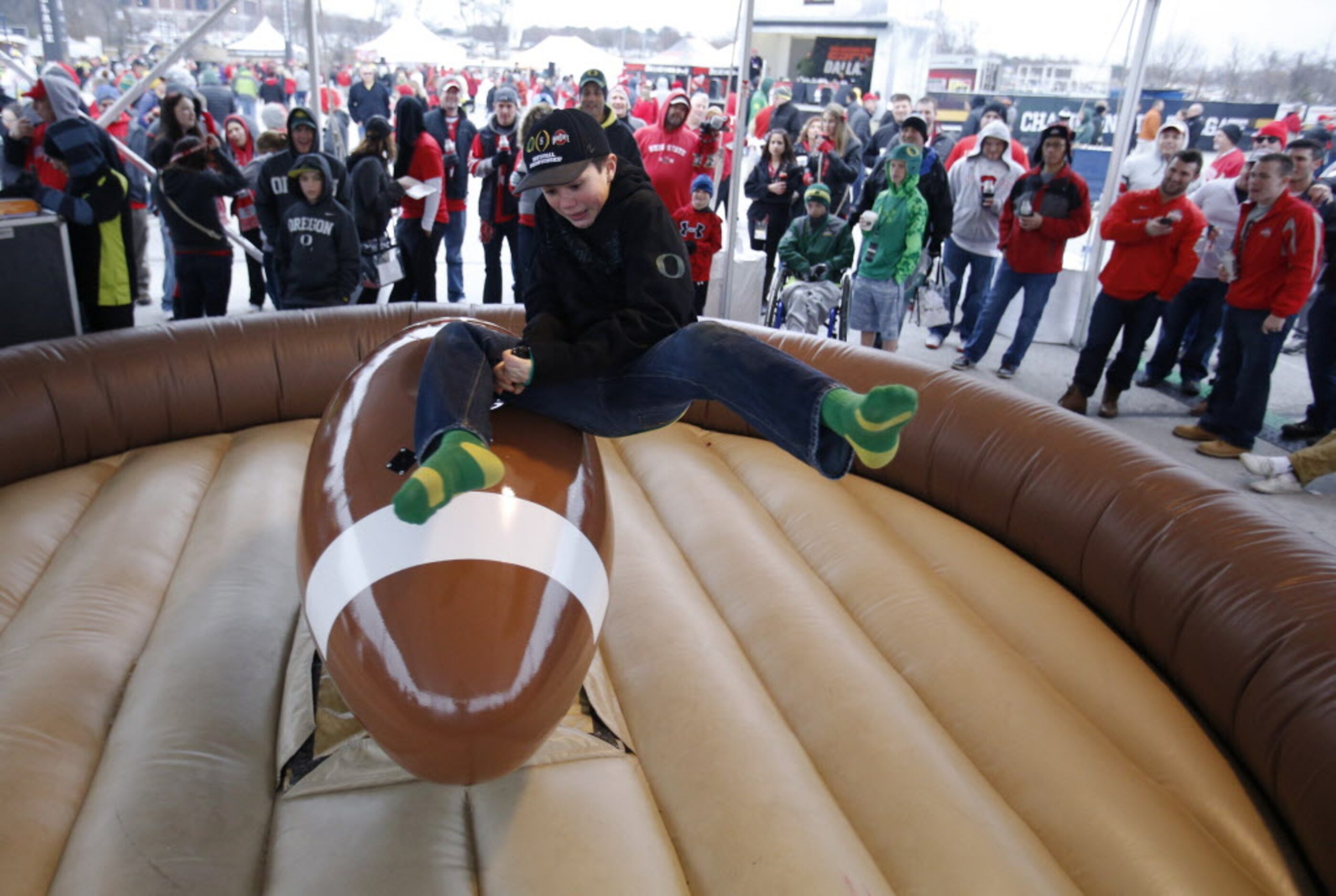 Joe Cross, 12 of Bend,Oregon falls off as he rides the "footbull" before a game between...