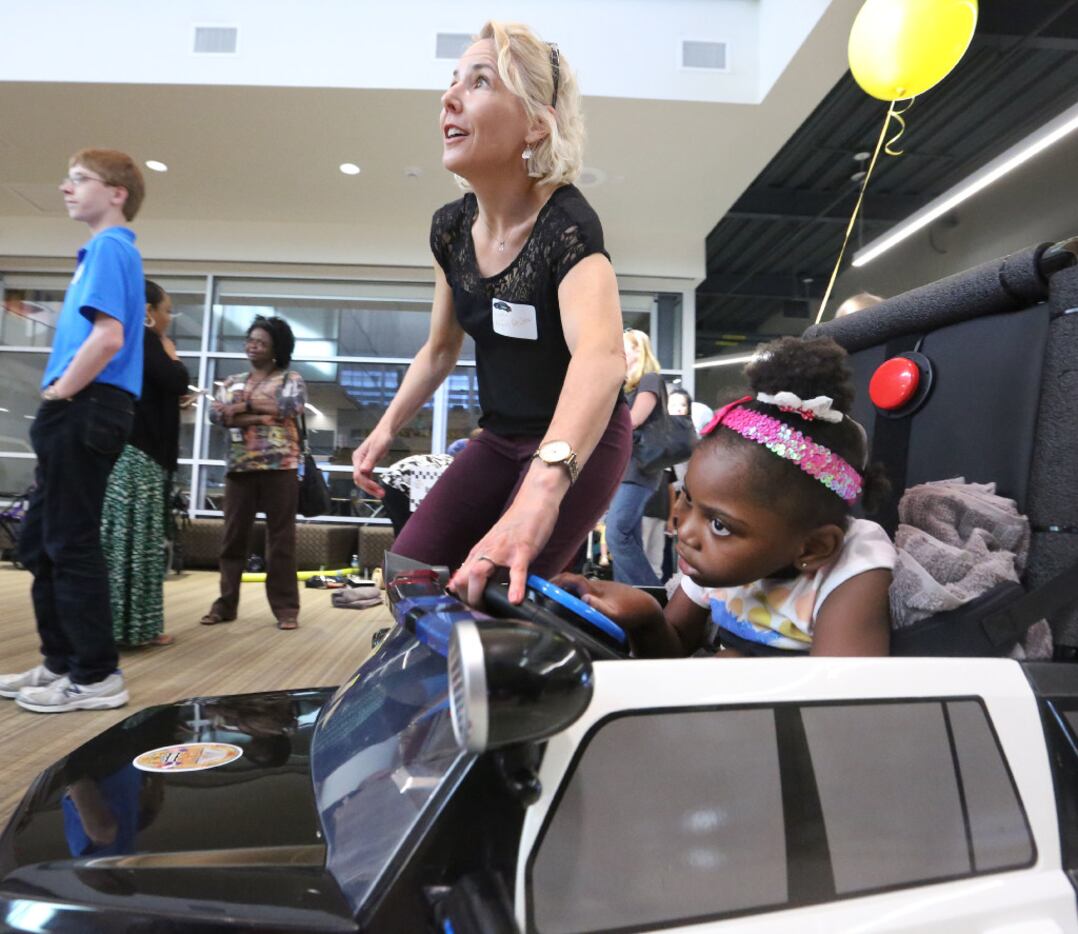 Angie Ngoma, 6,  takes a tour in her customized car with the help of Maggie Krueger, a...