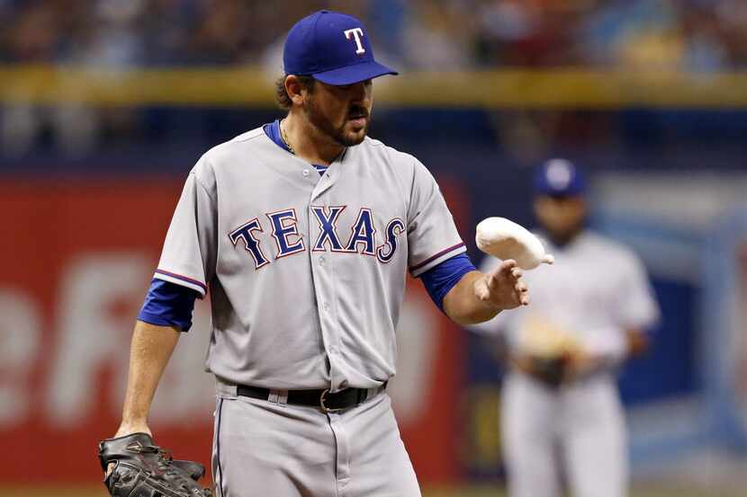 Texas Rangers starting pitcher Joe Saunders plays with the rosin bag after hitting Tampa Bay...