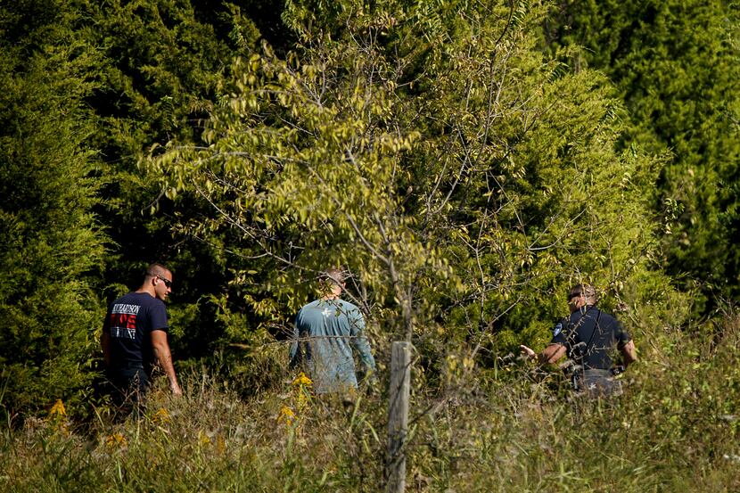 Police head into a wooded area as they search for Sherin Mathews last week on the campus of...