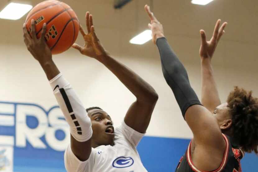 Grand Prairie's Jaylin Posey (1) skies to the basket against the defense of South Grand...
