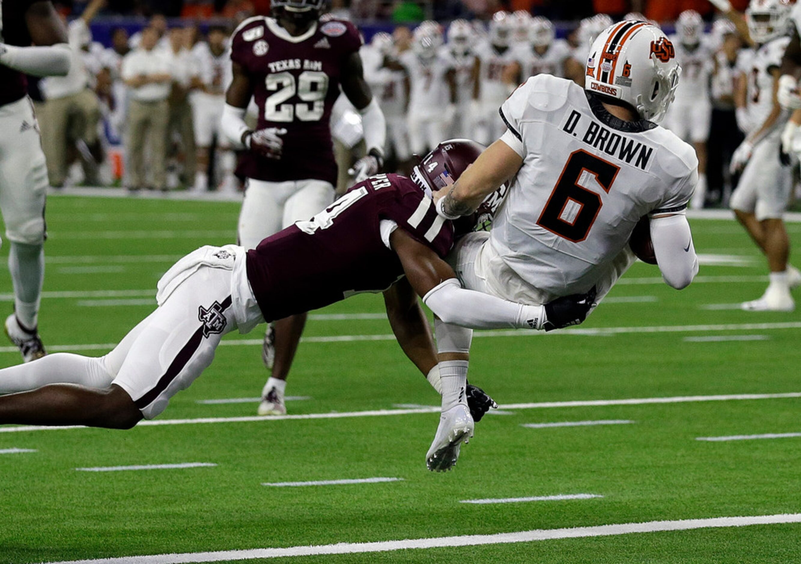 HOUSTON, TEXAS - DECEMBER 27: Dru Brown #6 of the Oklahoma State Cowboys scores on a nine...