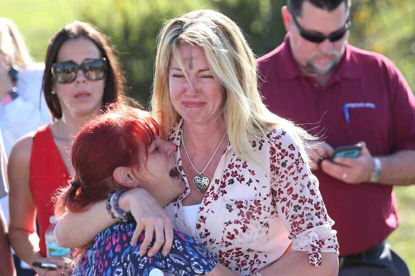 Parents wait for news after a reports of a shooting at Marjory Stoneman Douglas High School...