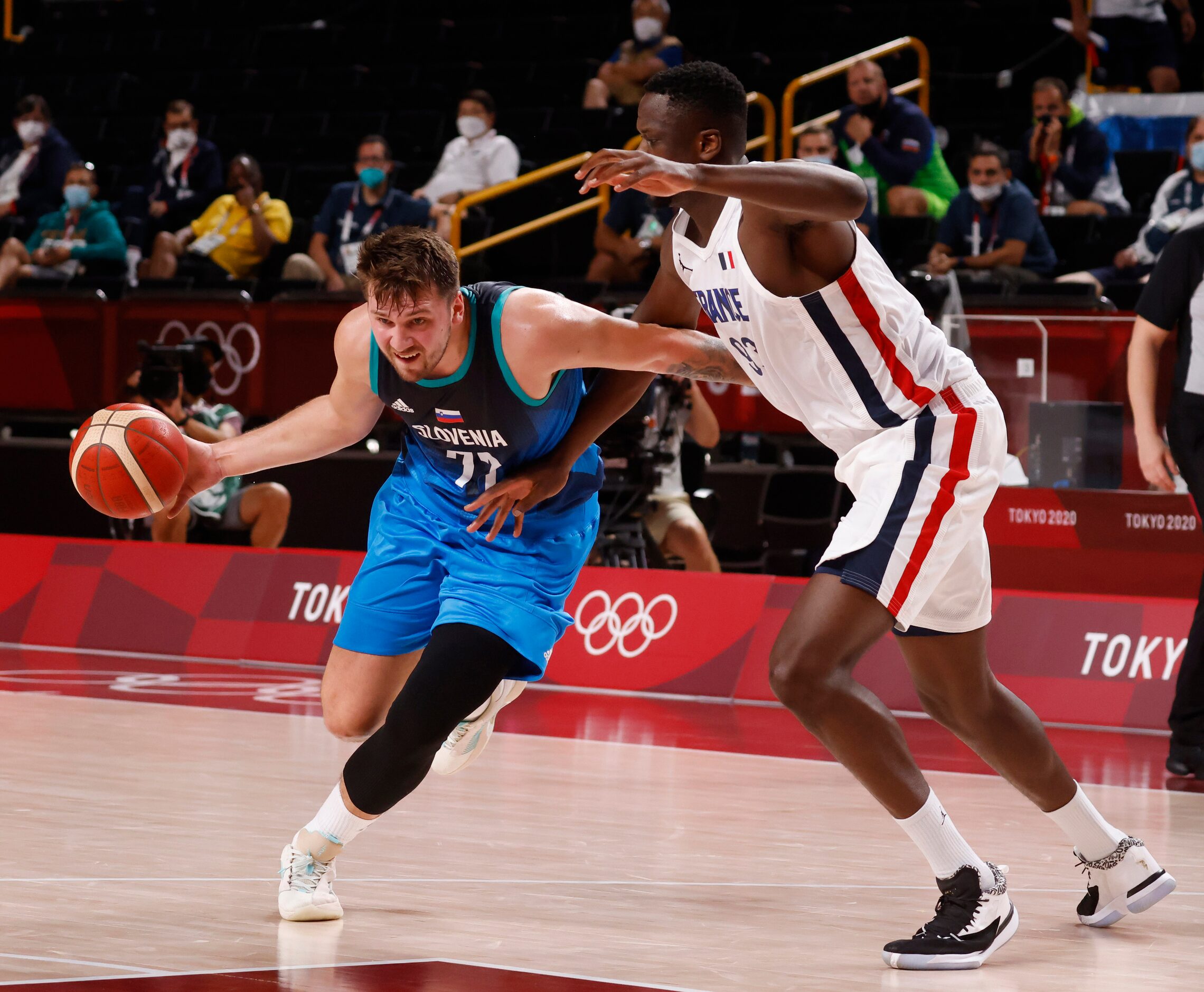 Slovenia’s Luka Doncic (77) drives to the basket as he is defended by France’s Moustapha...