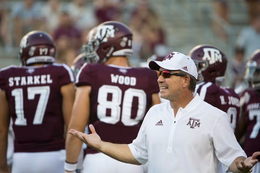 FILE - Texas A&M Aggies head coach Jimbo Fisher works with players during warmups prior to a...