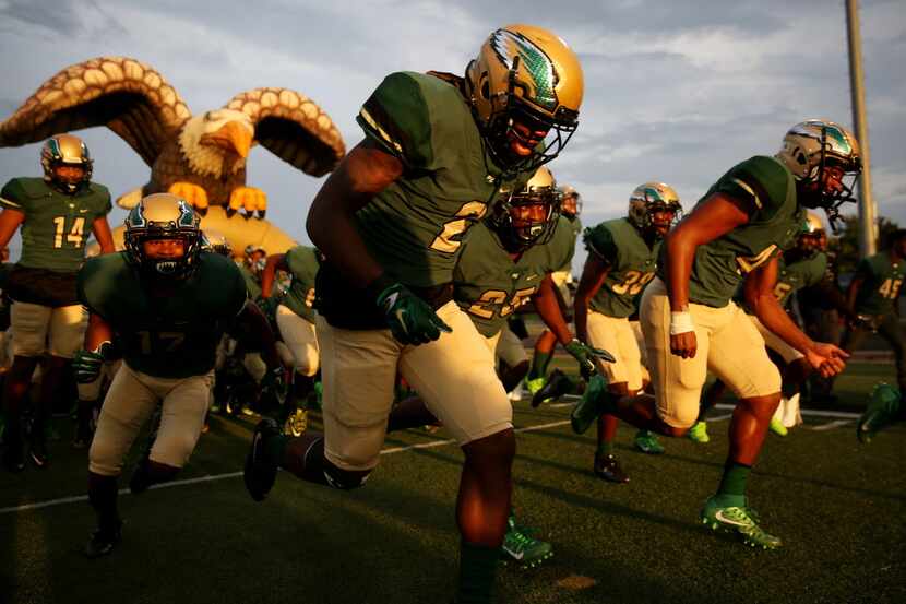 DeSoto players run onto the field before a high school football game between Jesuit and...