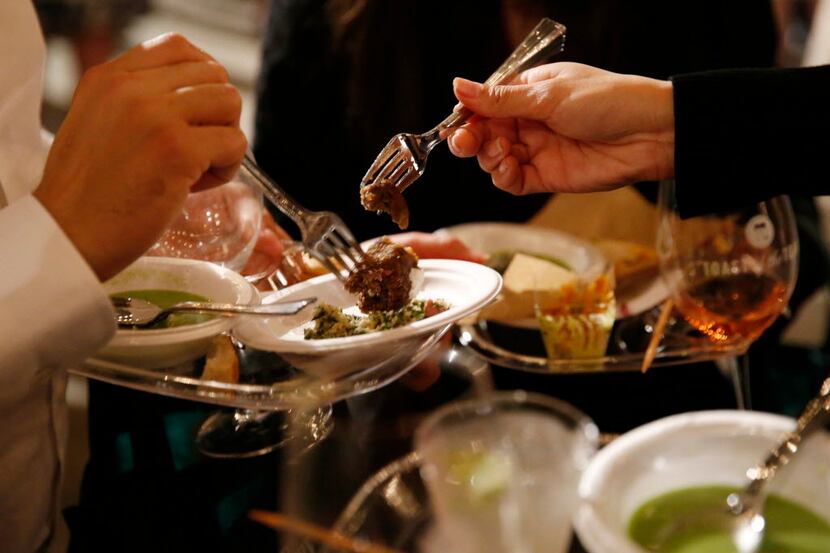 Guests try food during the Grand Tasting event at Savor Dallas at Fair Park in Dallas...