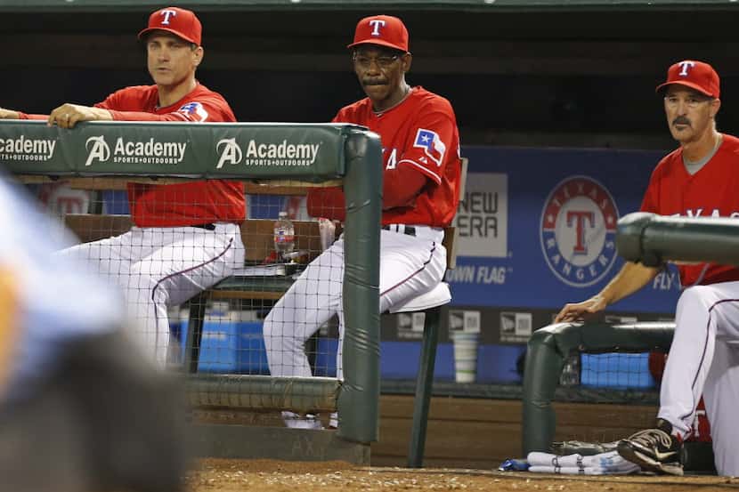 Texas bench coach Tim Bogar, manager Ron Washington and pitching coach Mike Maddux watch the...