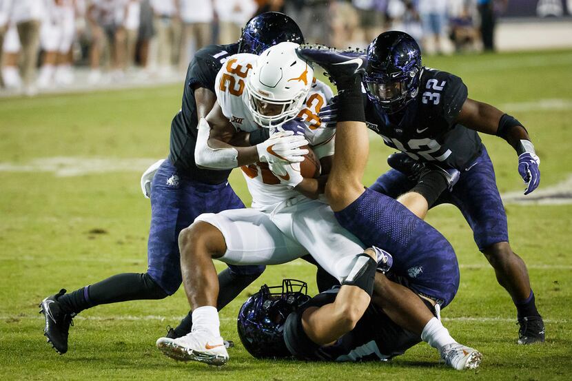 Texas running back Daniel Young (32) is brought down by TCU defensive end Michael Epley...