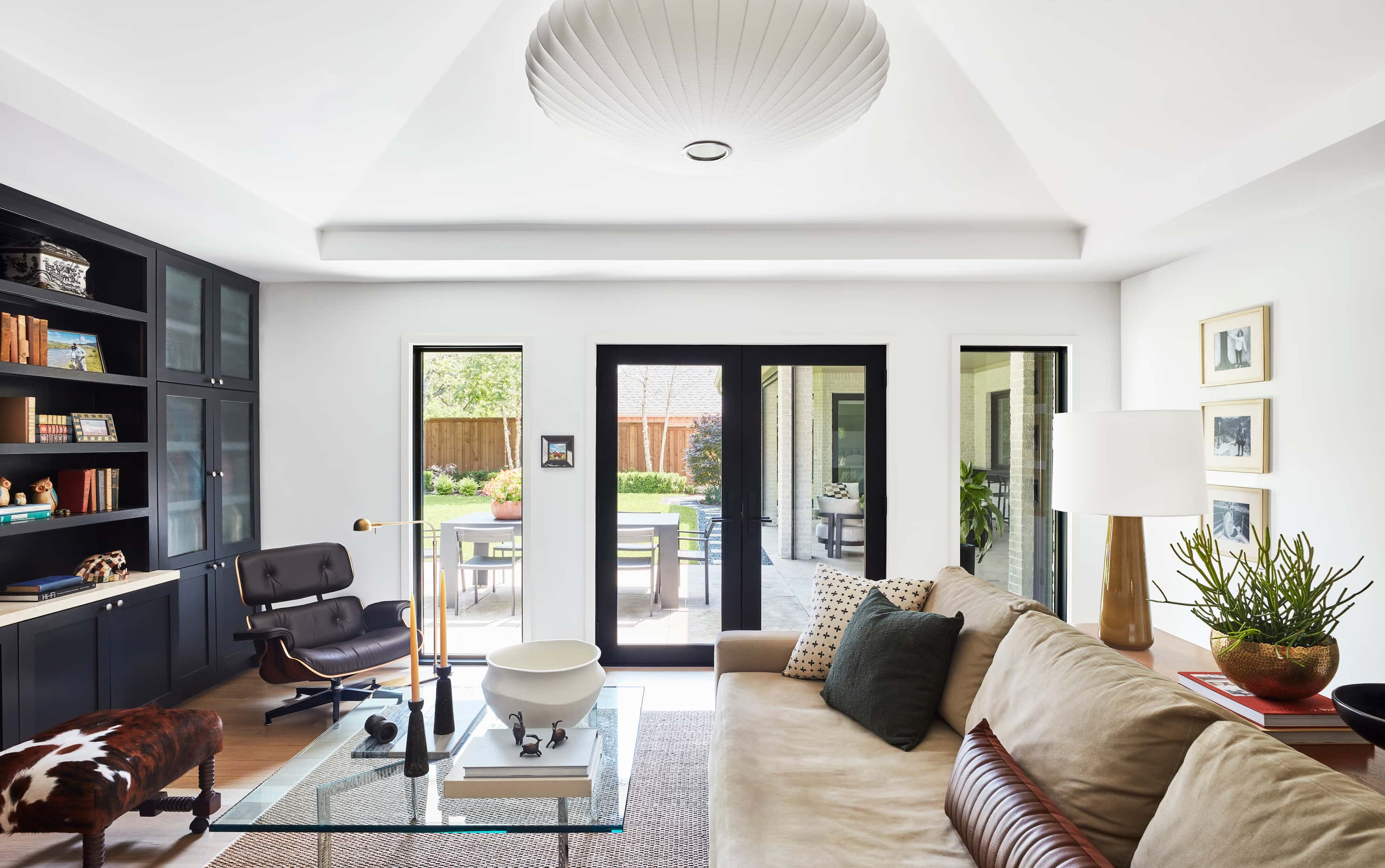 Family room with large couch, Eames chair in corner and navy built-in bookcases