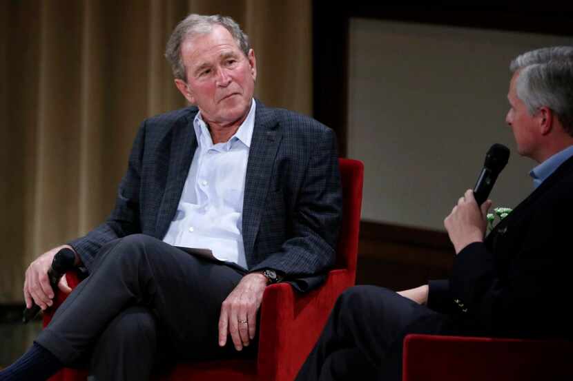 Former President George W. Bush listens as Jon Meacham, author of a new biography of former...
