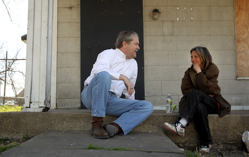 Larry James, then president and CEO of CitySquare, sits with a neighbor in front of an...