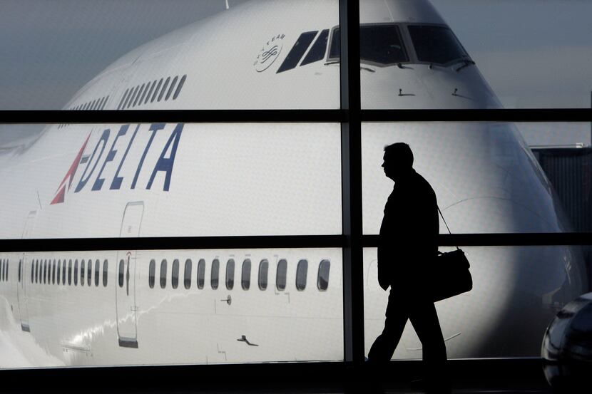 FILE - In this file photo made Jan. 21, 2010, a passenger walks past a Delta Airlines 747...