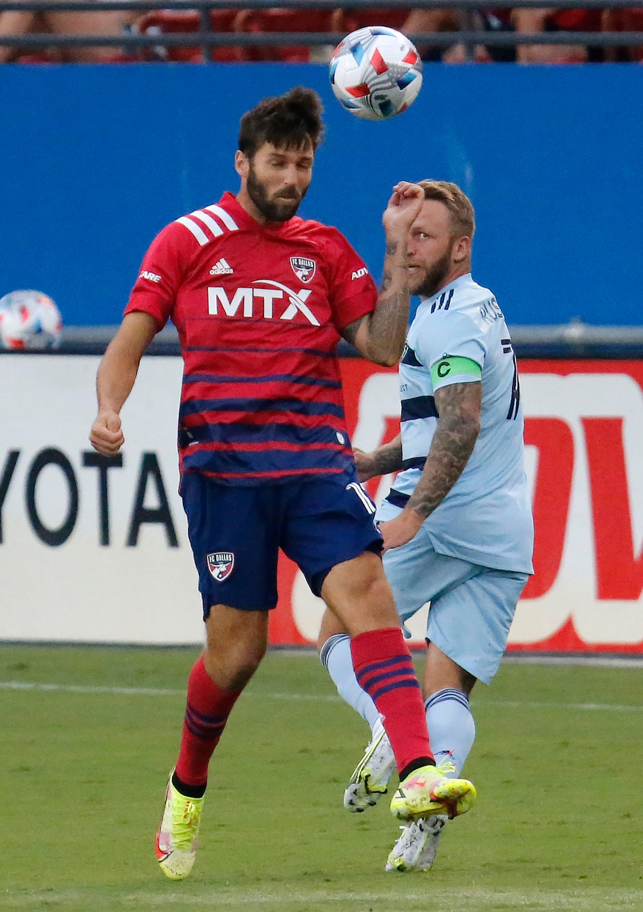 FC Dallas midfielder Ryan Hollingshead (12) gets a header in front of Sporting Kansas City...