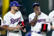 Texas Rangers starting pitcher Nathan Eovaldi (left) laughs as right fielder Adolis Garcia...