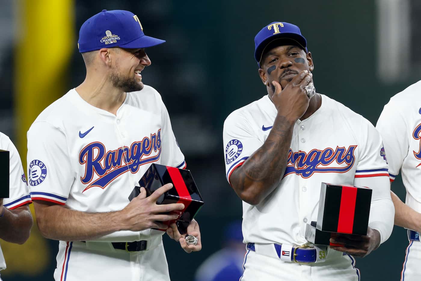 Texas Rangers starting pitcher Nathan Eovaldi (left) laughs as right fielder Adolis Garcia...