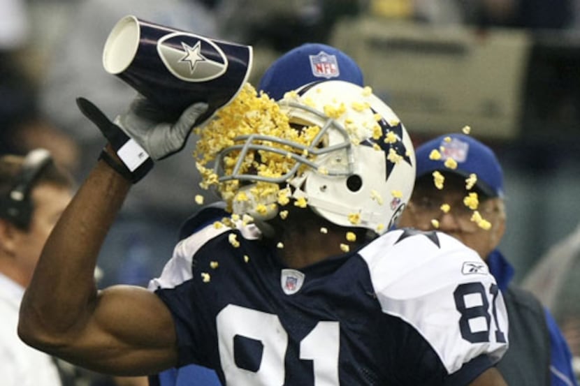 Dallas Cowboys wide receiver Terrell Owens (81) throws popcorn in his face after scoring in...