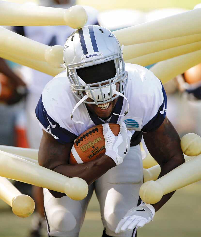 Cowboys running back Rod Smith's helmet begins to come off as he runs through a drill during...