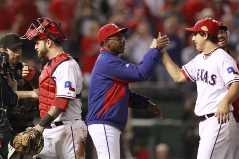 Texas Rangers manager Ron Washington congratulates pitcher Derek Holland as Mike Napoli...