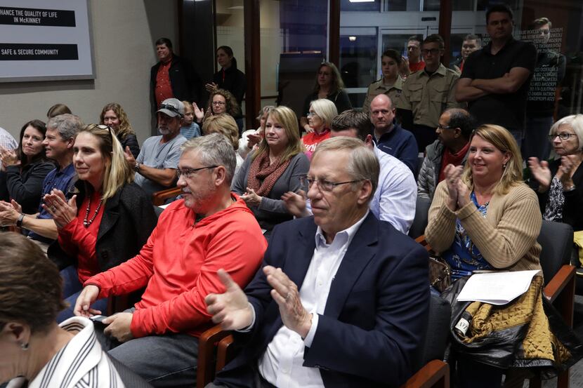Citizens applaud an announcement to cancel annexation plans during a council meeting at City...
