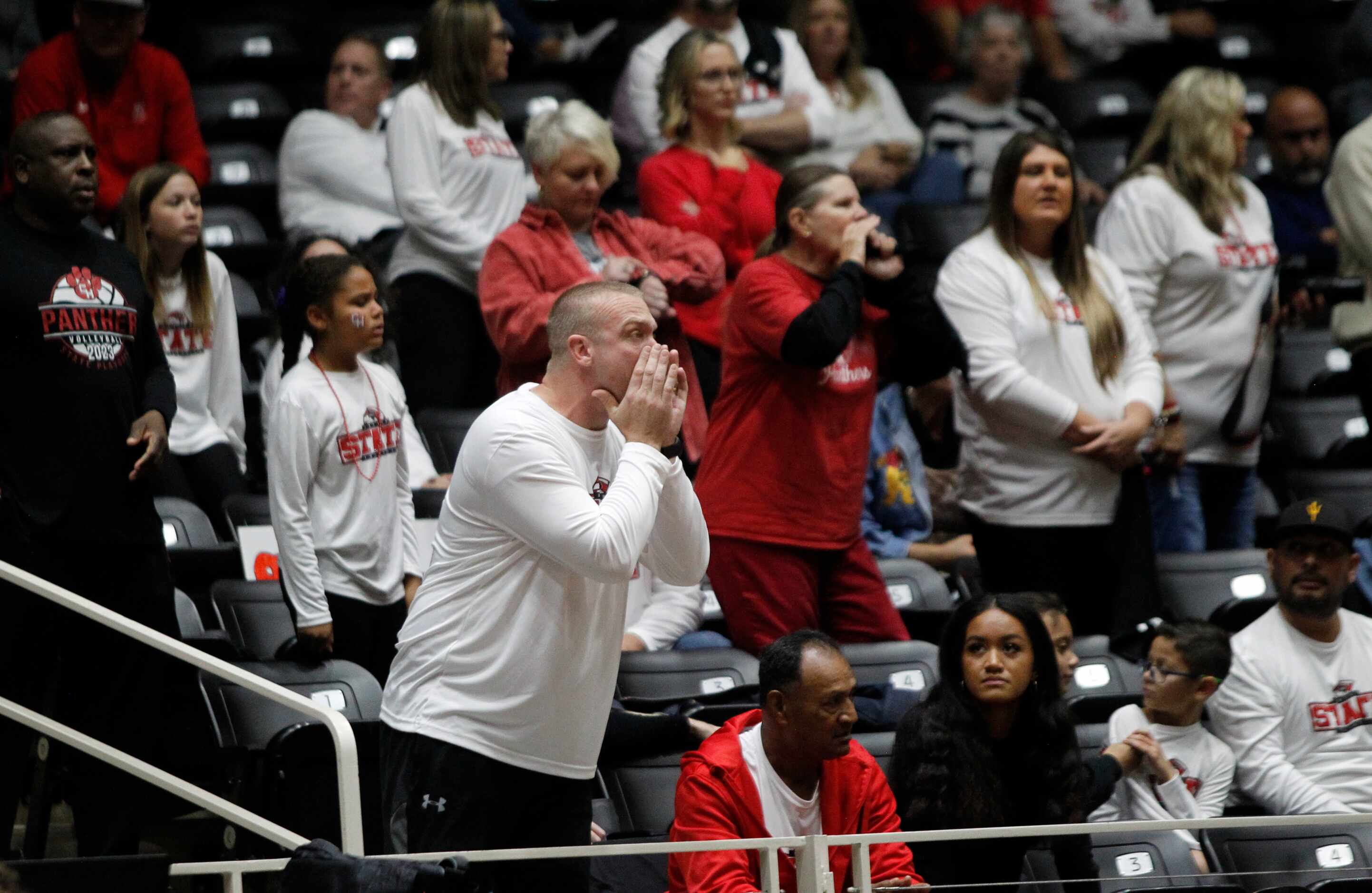Colleyville Heritage fan and dad David Davis, left, voices his support for the team and his...