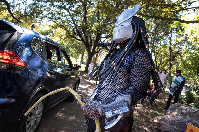Mayor Pro-Tem Adam Medrano sports a Predator costume while greeting families as they...