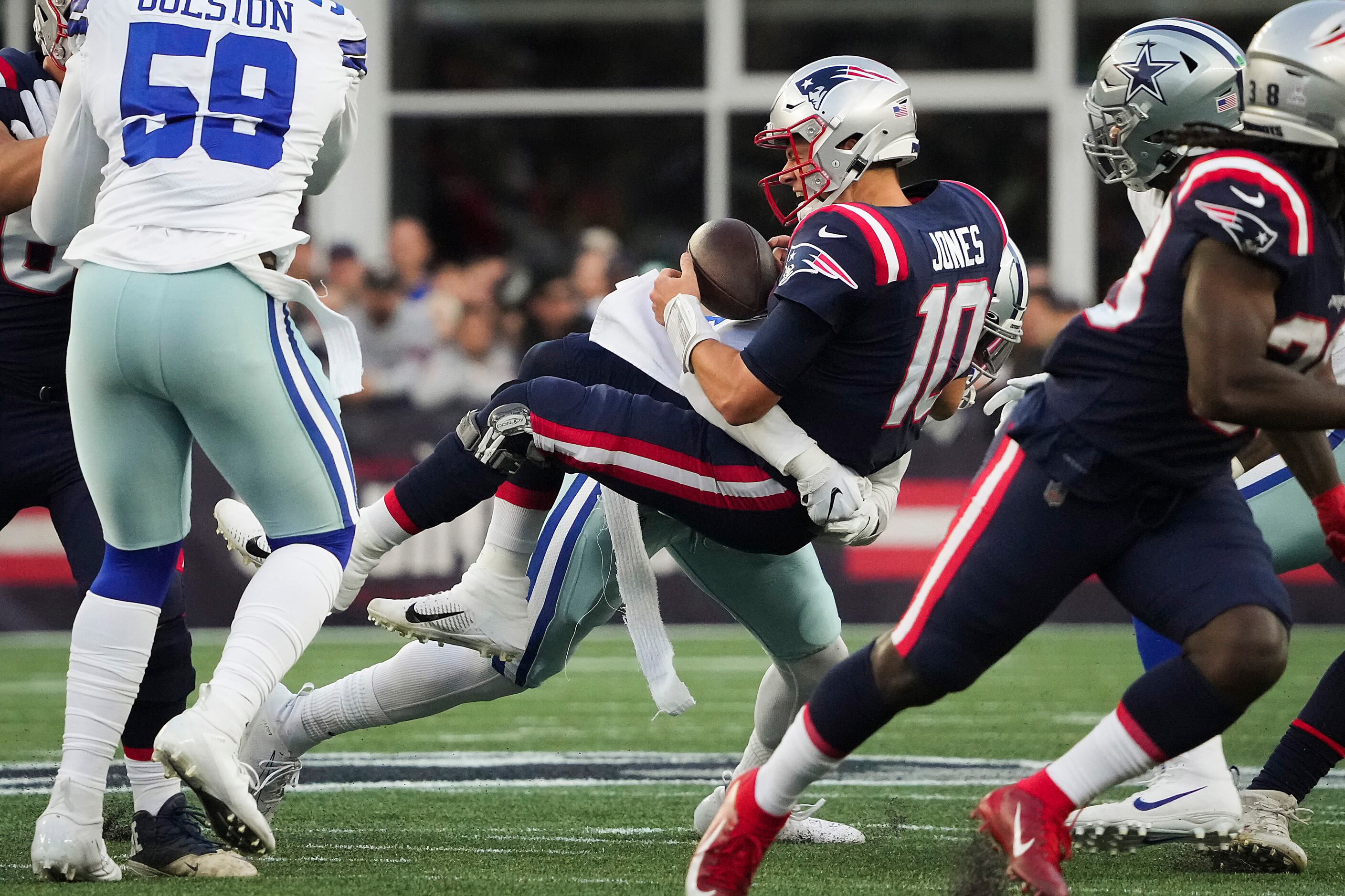 New England Patriots quarterback Mac Jones (10) fumbles as he is sacked by Dallas Cowboys...