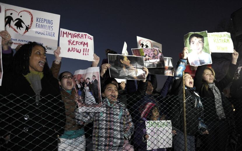 Immigration reform protesters gather outside the fence for the lighting of the 2013 U.S....