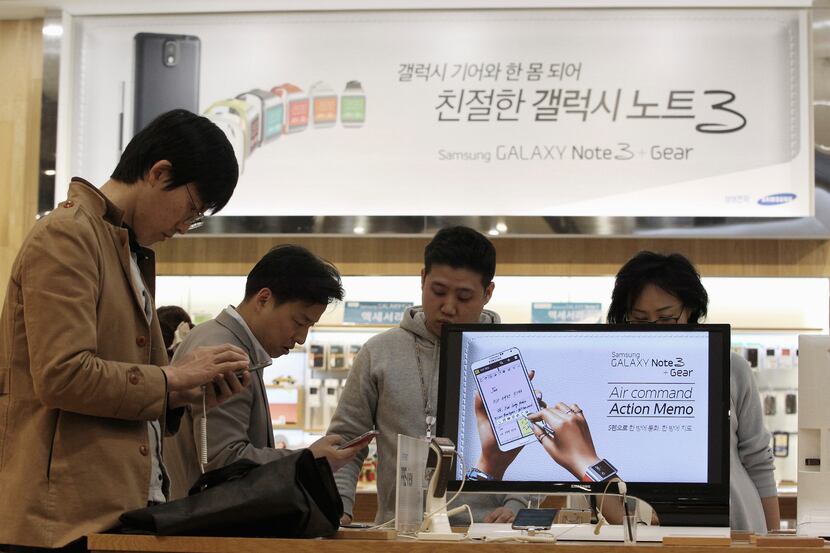 Visitors try out Samsung Electronics Co.'s Galaxy Note 3 at its showroom in Seoul, South...