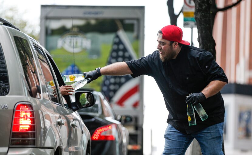 John Sumner, Assistant Culinary Director of Hero by HG Sply Co., hands off free bottles of...