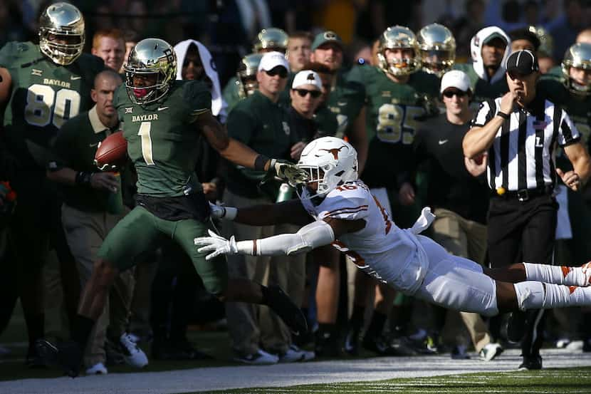 Baylor wide receiver Corey Coleman (1) is pushed out of bounds by Texas defensive back...