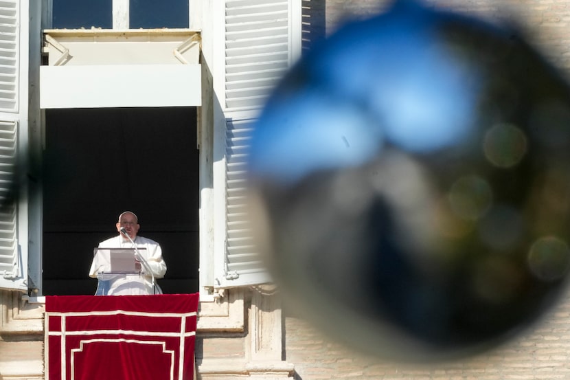 Pope Francis delivers his blessing as he recites the Angelus noon prayer from the window of...