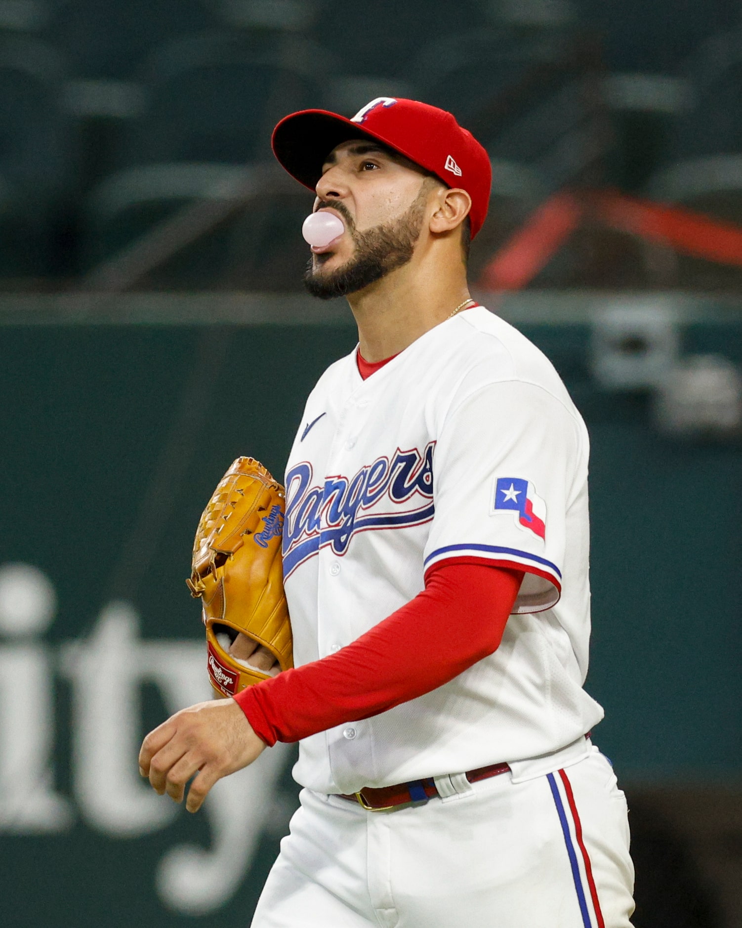 Texas Rangers starting pitcher Martin Perez (54) blows a bubble as he walks to the mound...