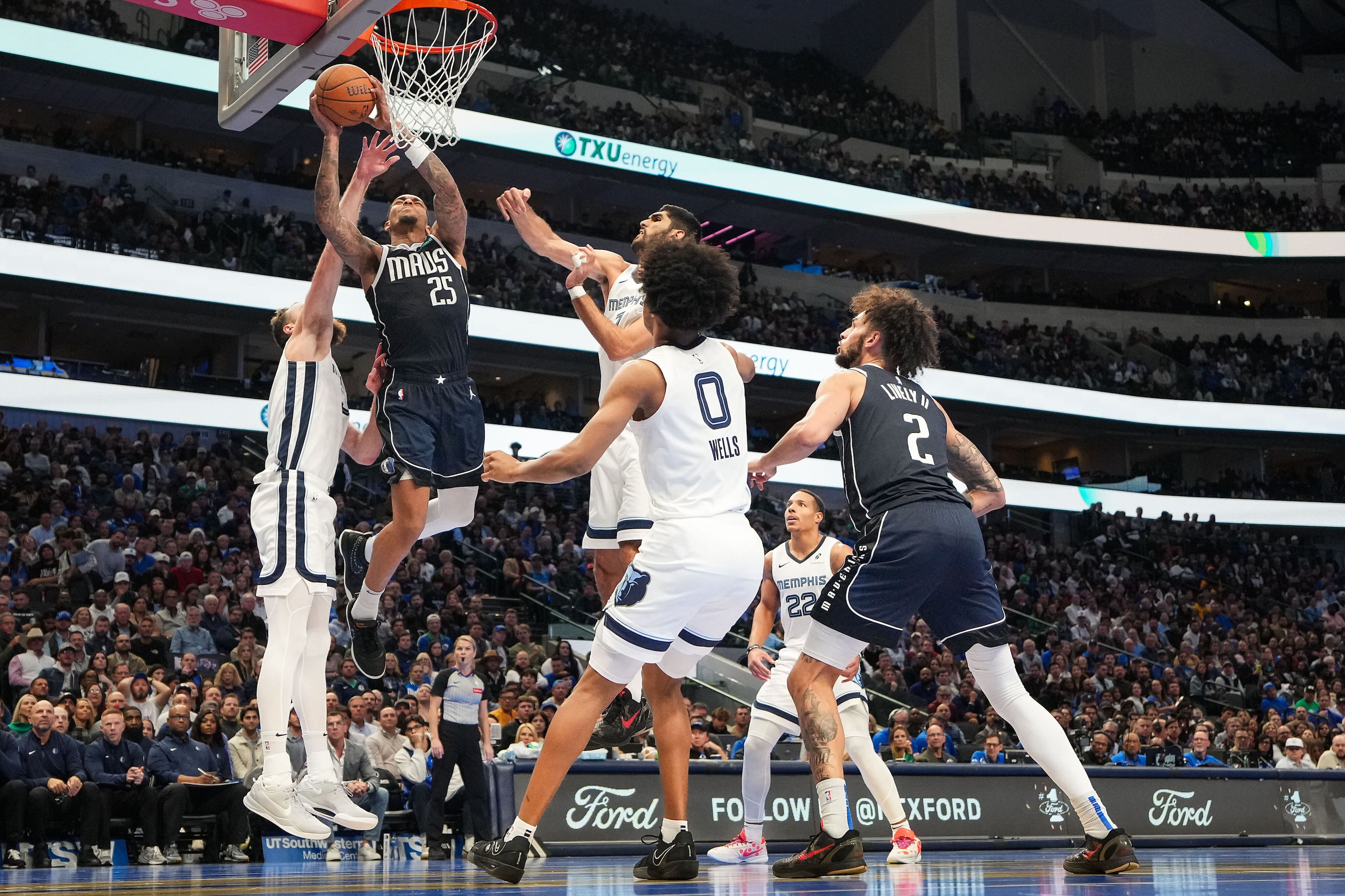 Dallas Mavericks forward P.J. Washington (25) drives to the basket between Memphis Grizzlies...