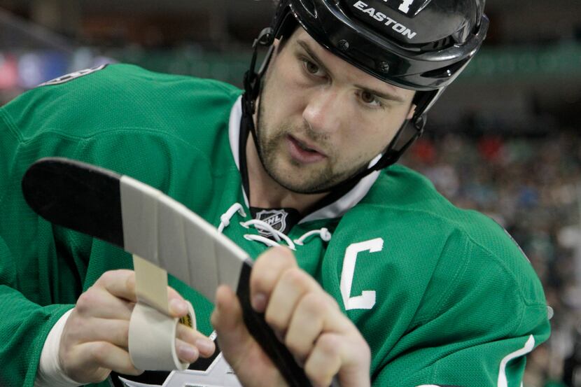 Dallas Stars left wing Jamie Benn (14) tapes up his stick in the first period of NHL Hockey...
